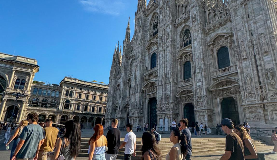 Group of students walking past the Duomo in Milan on a sunny morning