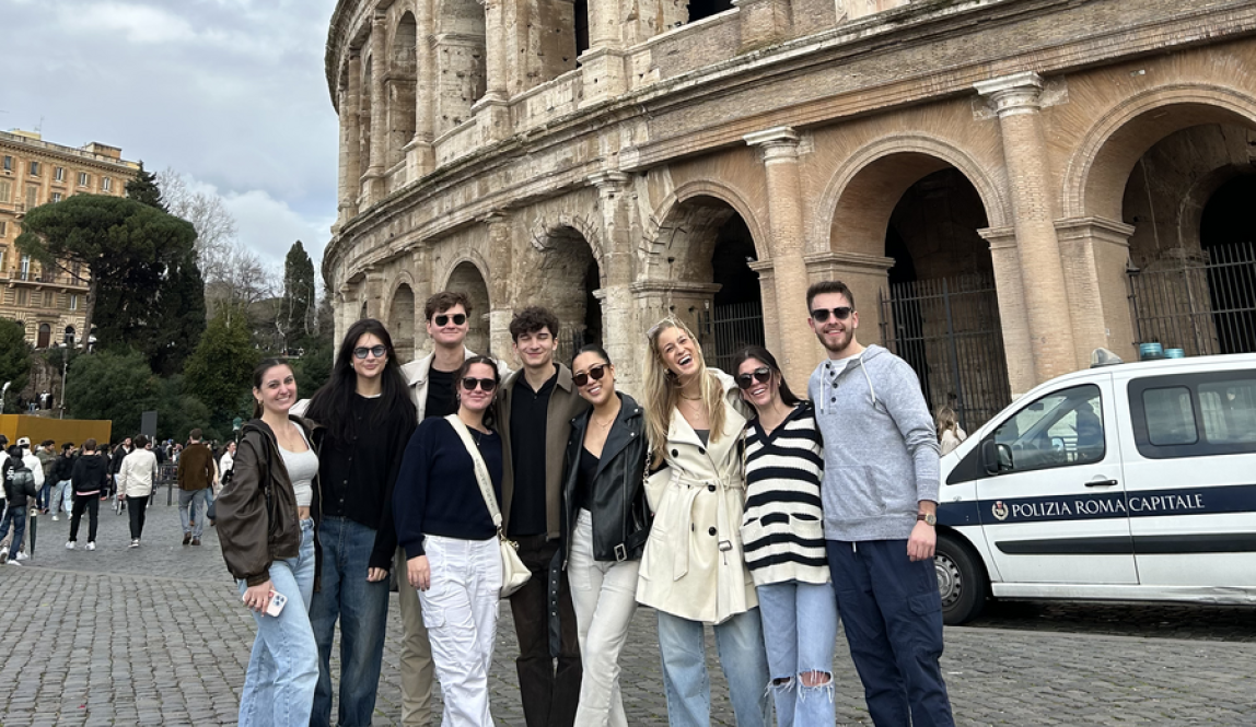 Students standing in front of the Colosseum smiling