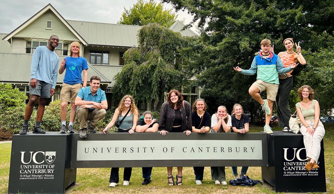 a group of students pose for a photo with the UC Canterbury sign