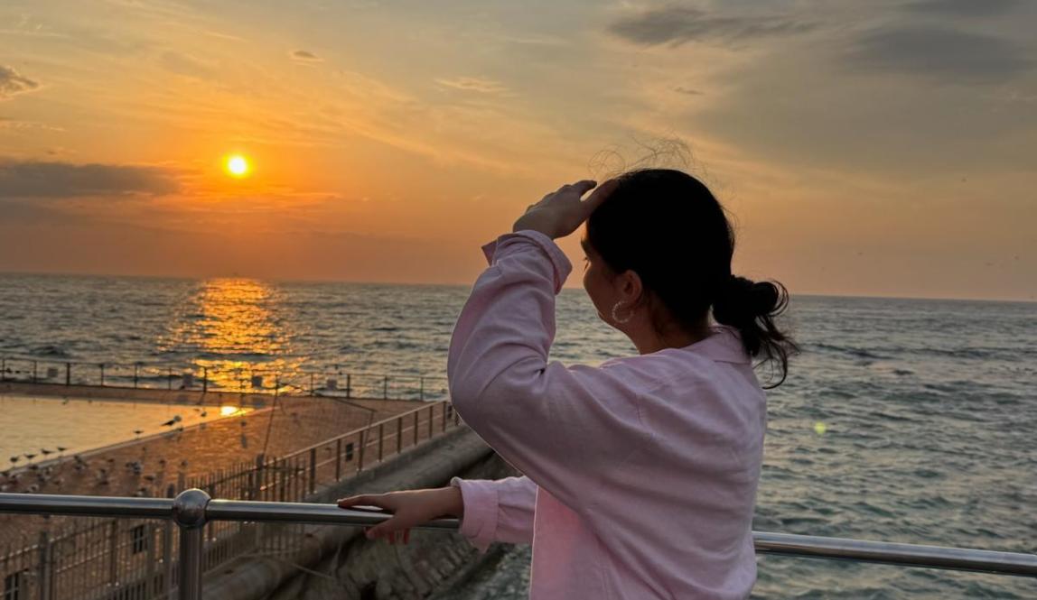 a person looking towards the sunset 