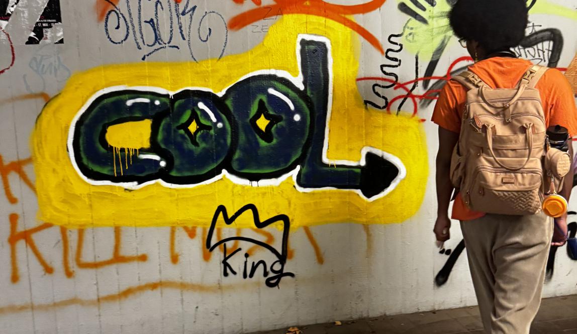 Person standing next to graffiti