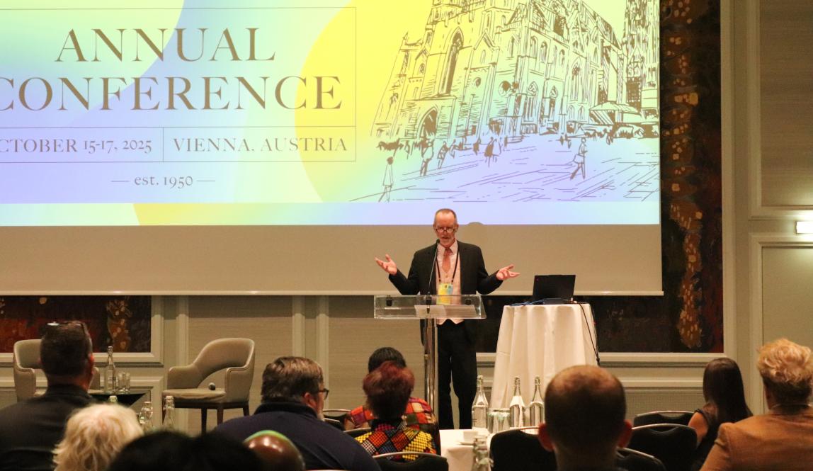 A man stands behind a podium in an auditorium