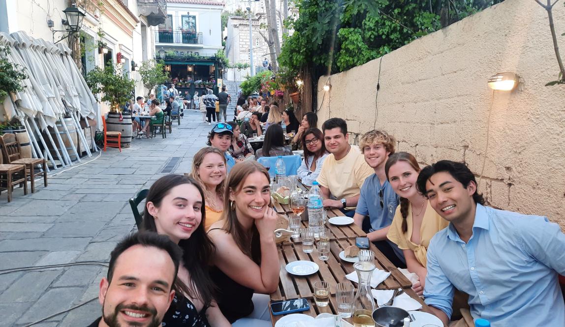 Students at a dining table outside in Athens