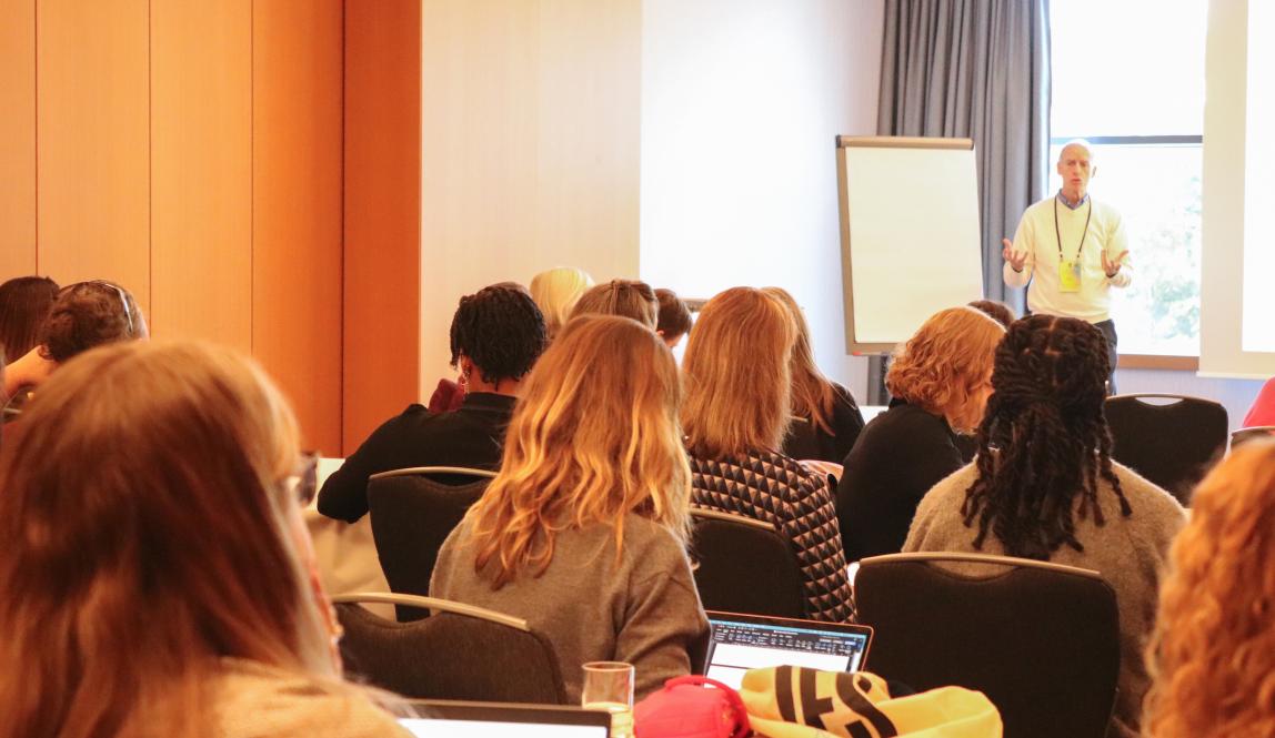 A group of people listening to a presentation