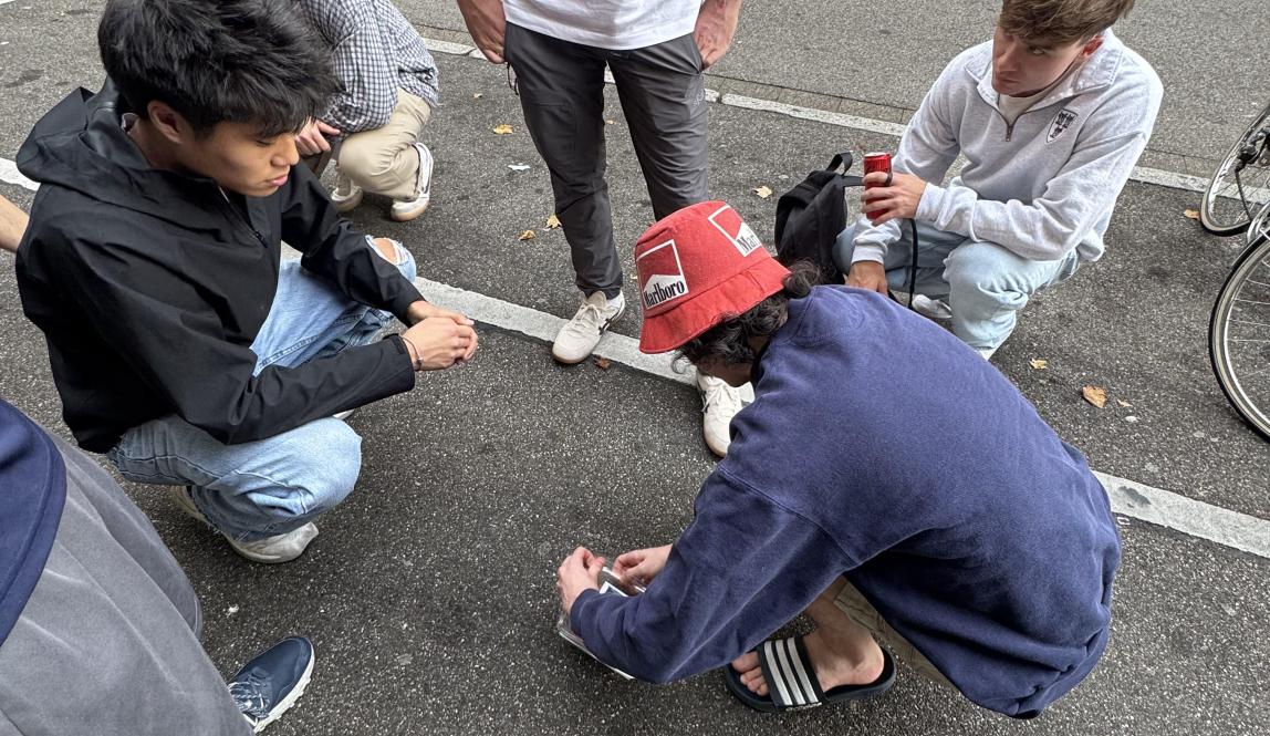 People on the sidewalk trying to open something