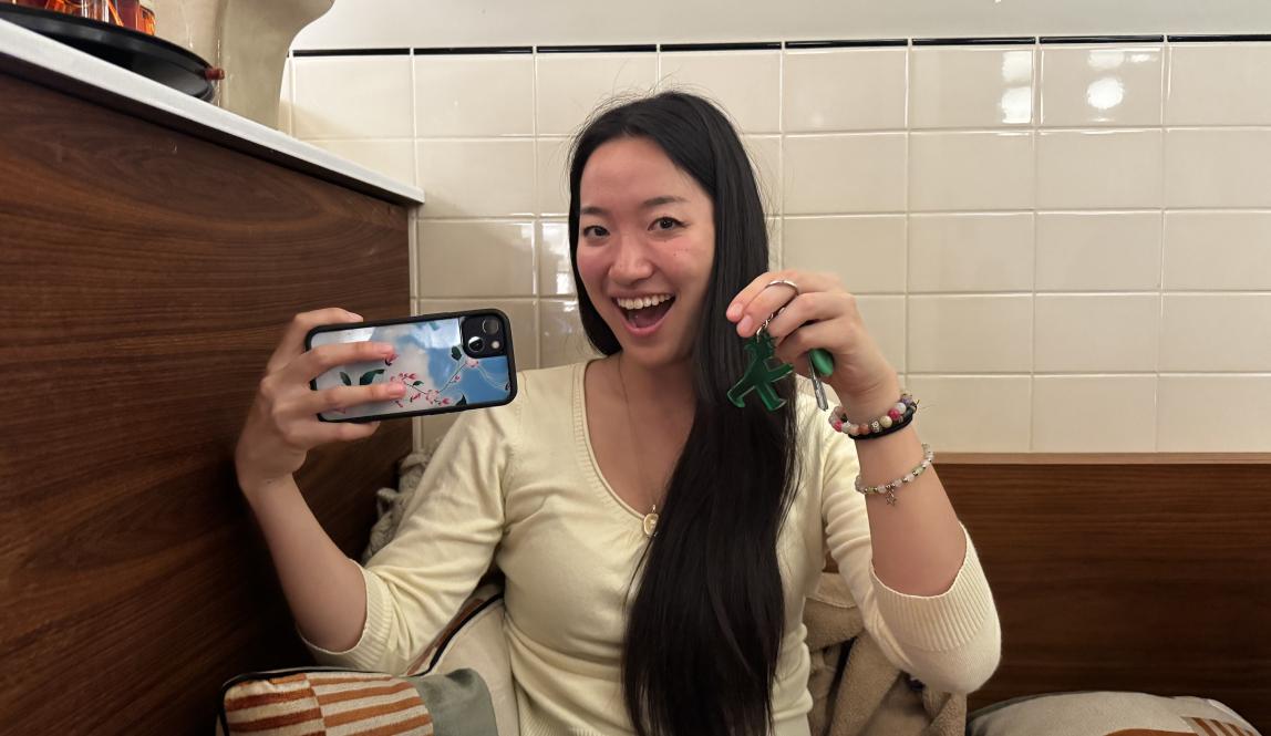 Girl holding up her phone and keychain for a photo