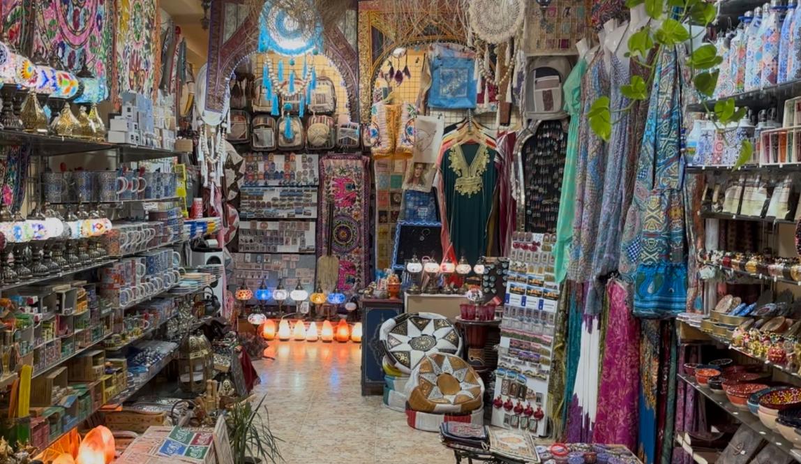 An Arabic market full of clothing, lamps, and jewelry