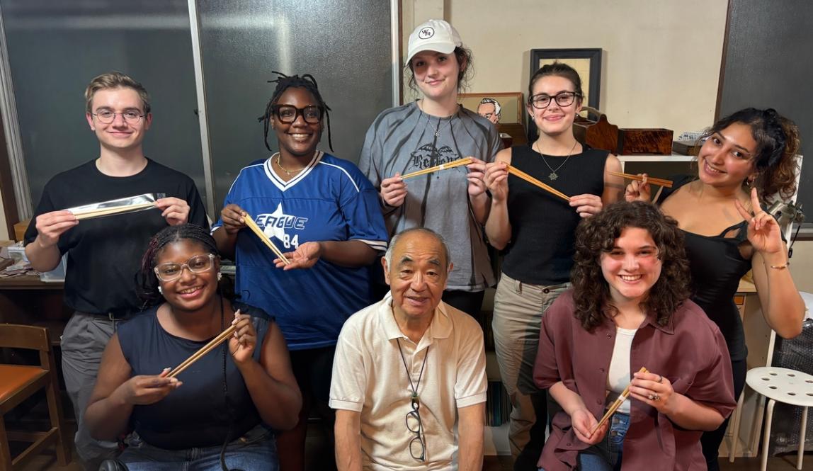 Sudents smiling with chopsticks during a cultural activity in Tokyo