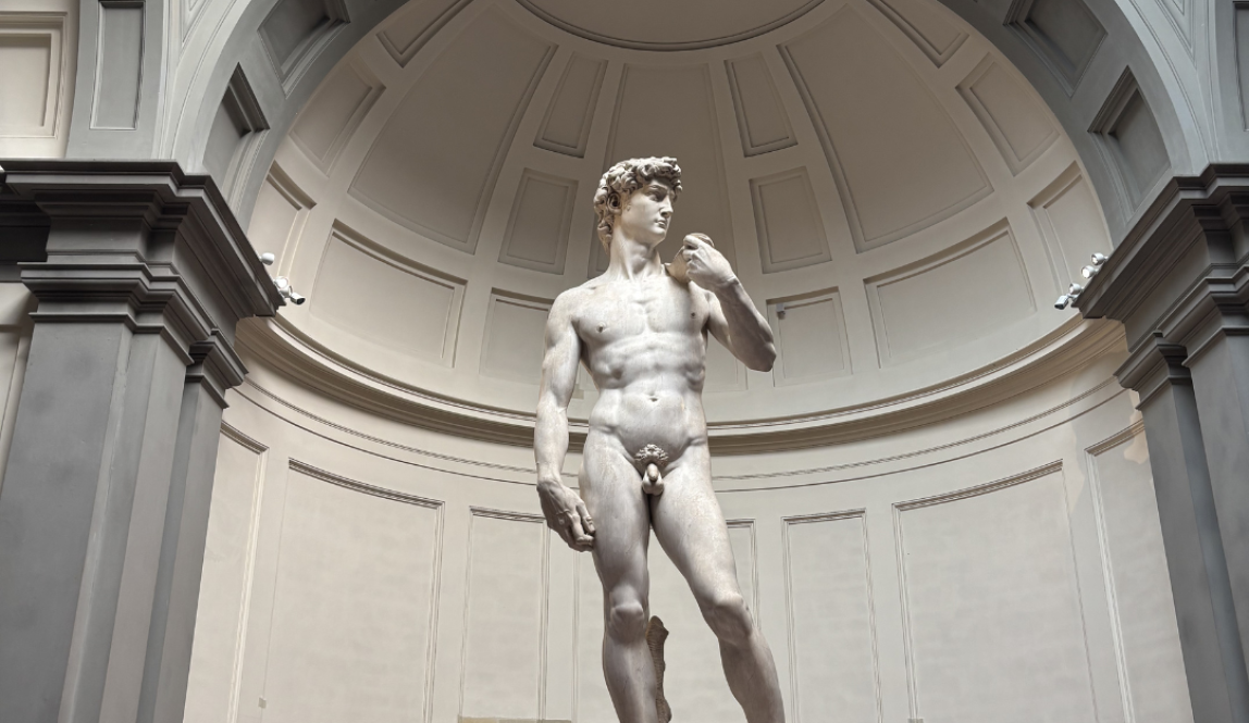 A large sculpture of a man with one hand raised and one hand at his side.