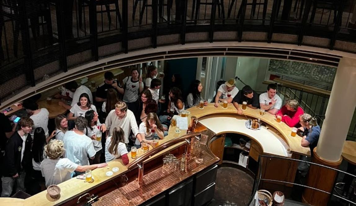 Aerial shot of a group of people in a bar, chatting and drinking.