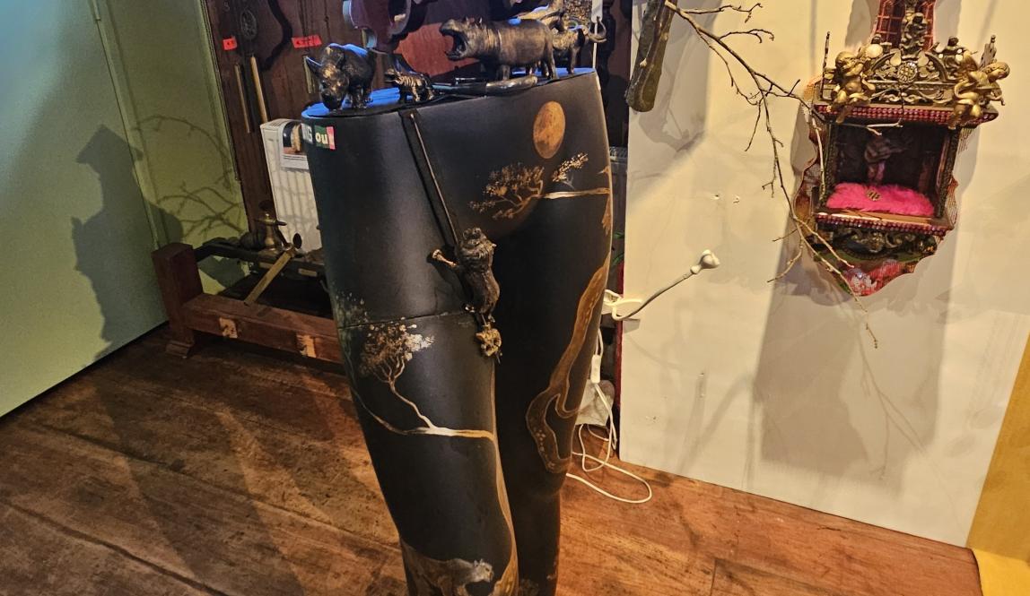 A clock carved into the top of the torso of a gold and black mannequin 