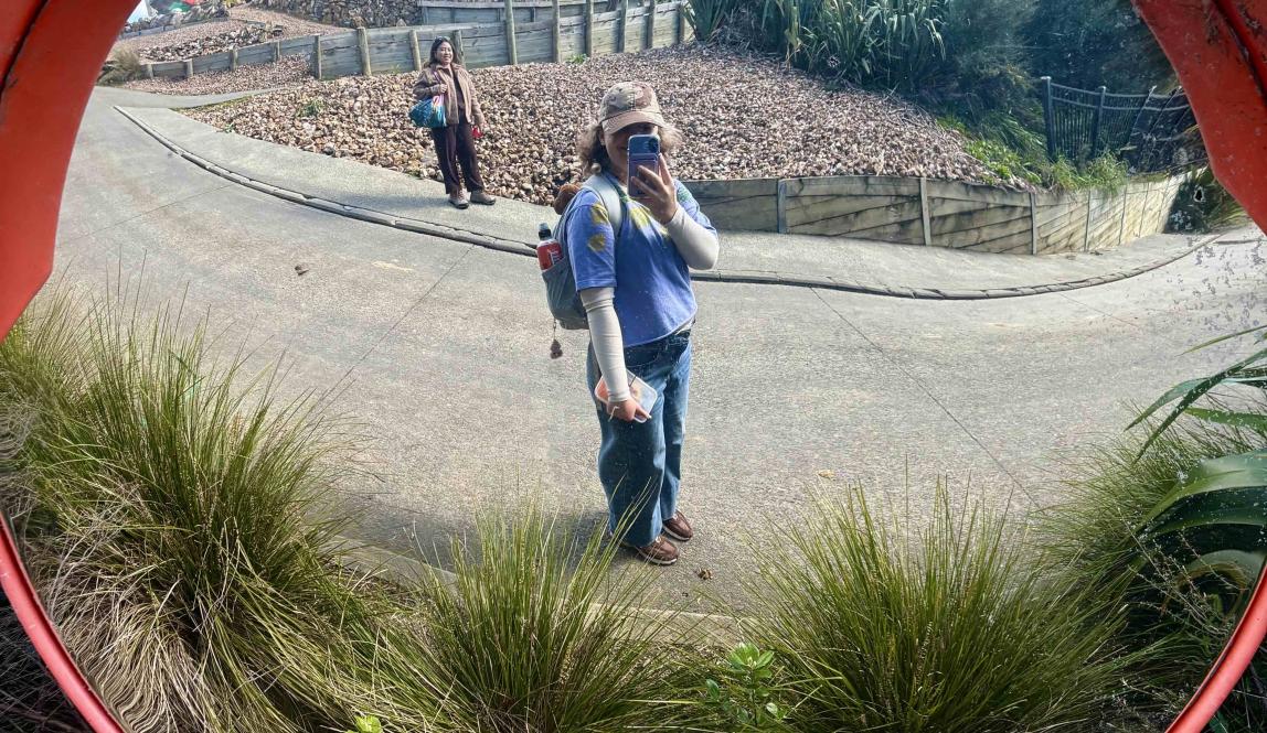A selfie in the reflection of a fish eye mirror on the side of the Te Ara Hura trail.
