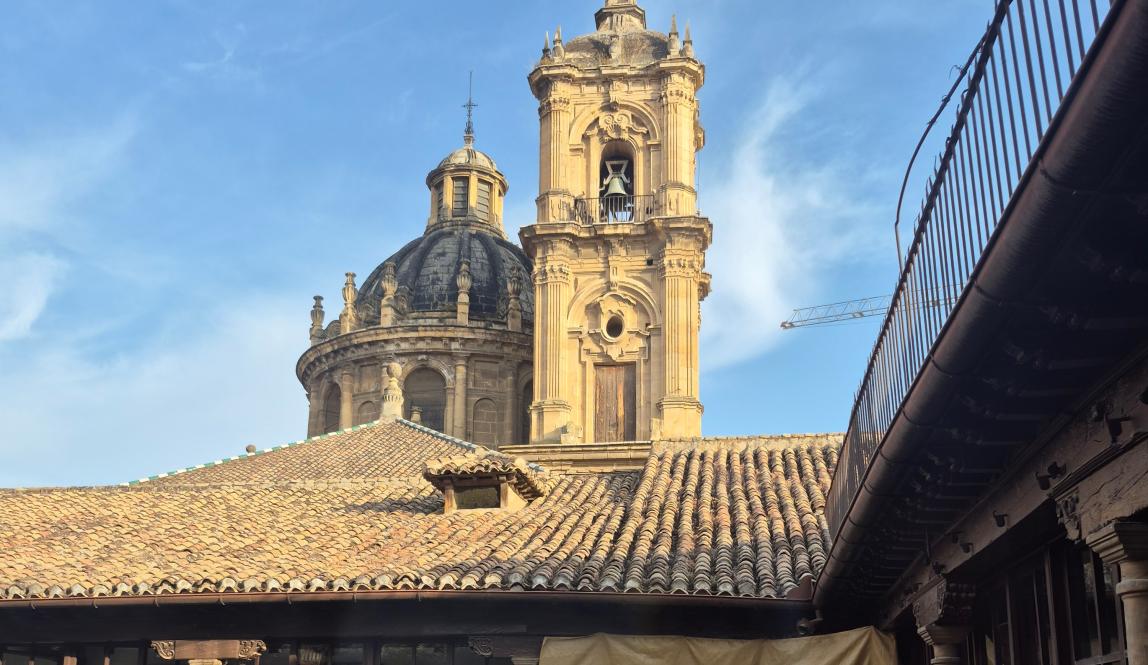 A church tower and dome in the background of an open courtyard