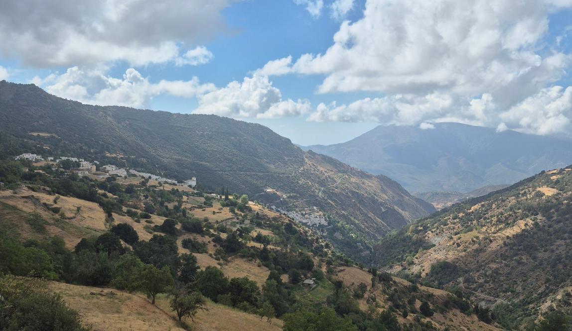 A mountain range with two white towns in the distance