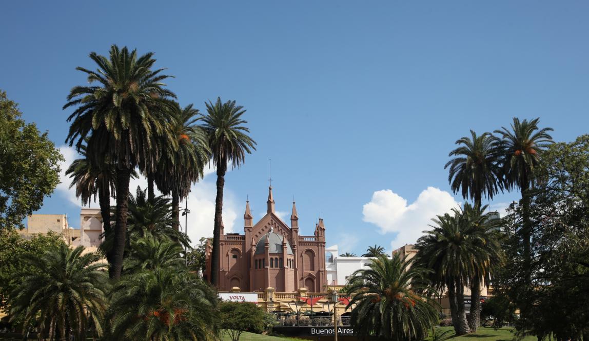 a scenic building in a palm tree-lined Buenos Aires park on a clear day