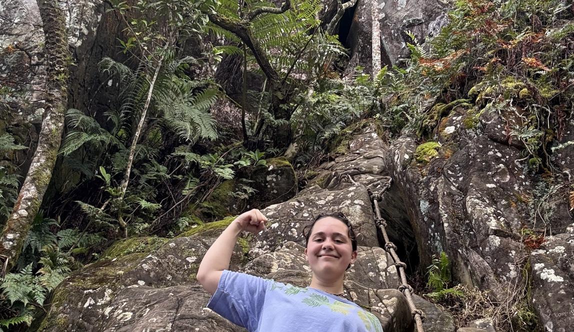 Pono posing in front of the rock climb up to Raemaru summit.