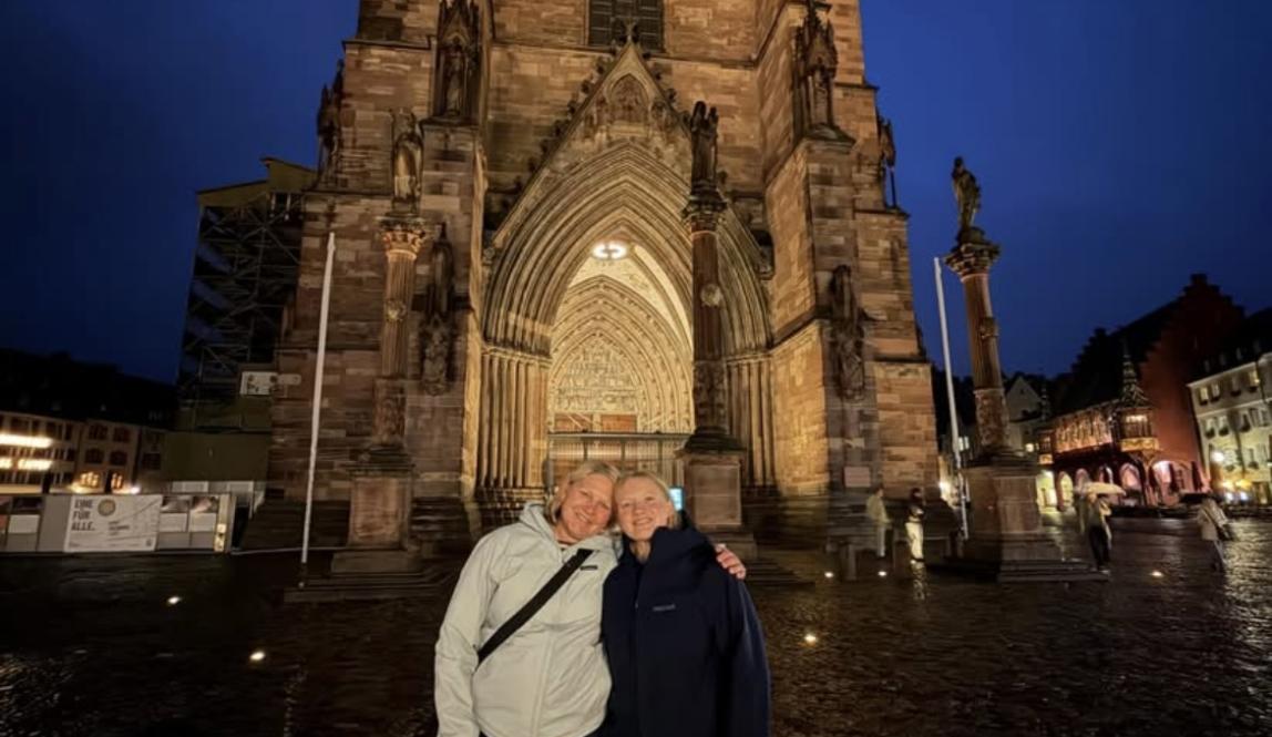 The author and her mom standing in front of the Freiburg Münster on a rainy night
