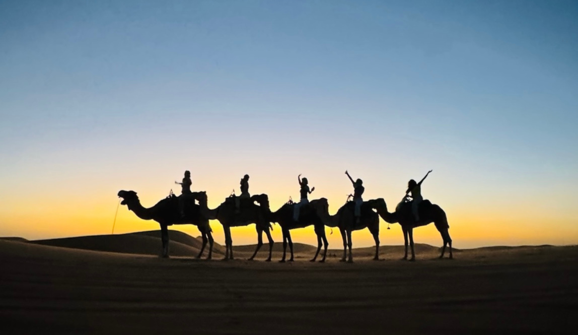 IES Abroad students riding camels in a Moroccan desert