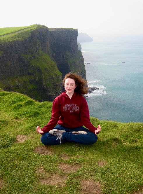 a student meditating near the Cliffs of Moher in Ireland