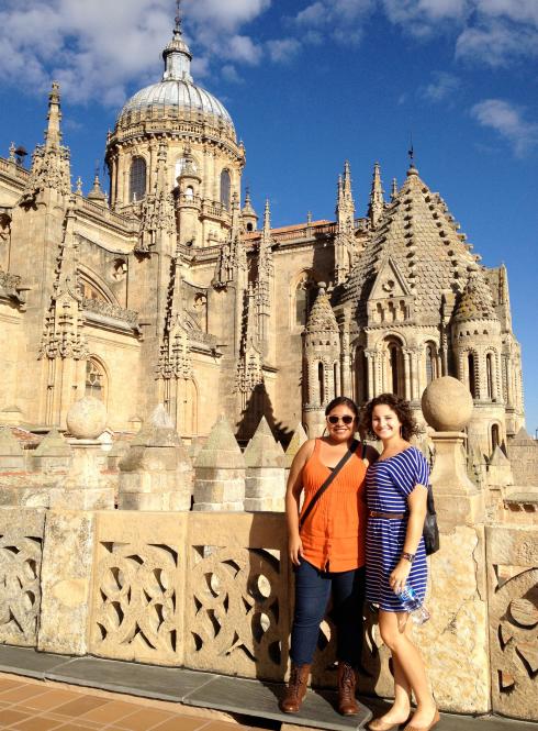 two students pose for a photo in front of the New Cathedral of Salamanca