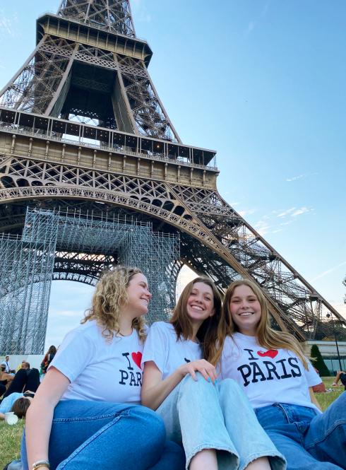 three female students having fun at the Eiffel Tower