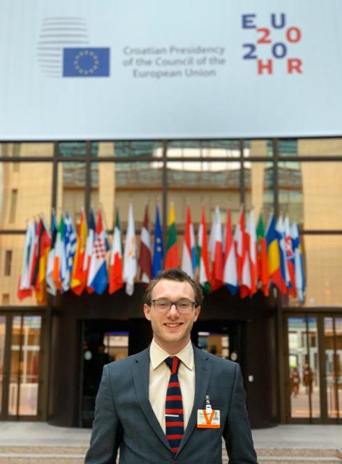 Male student standing in front of the EU council building