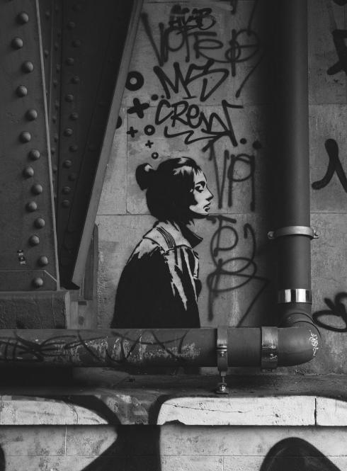 A wall with graffiti and the painting of a woman in Berlin, Germany.