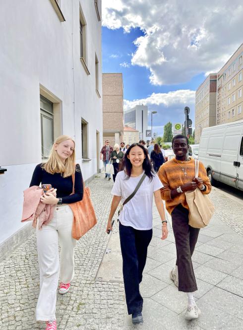 Three students walk on the sidewalk in Berlin, Germany.