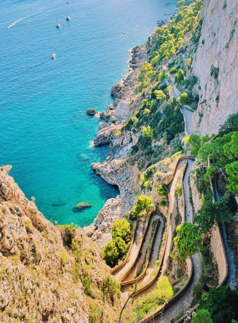 A view off of a cliff's edge of the ocean in Italy.