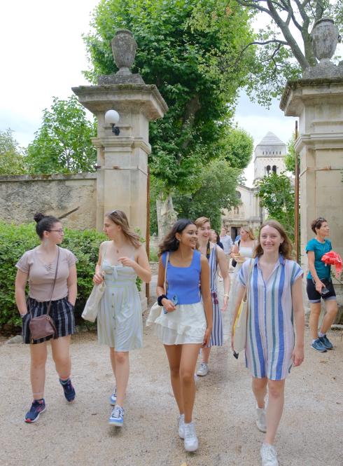 A group of students walk together down a road in Saint Rémy de Provence, France.