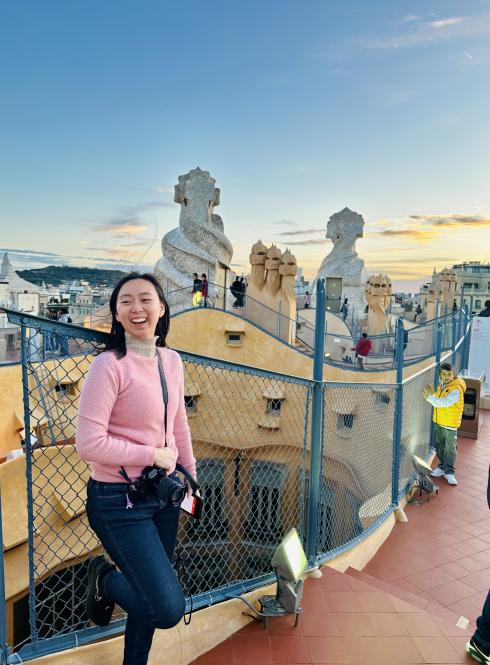 student standing on steps in front of colorful fence and textured buildings
