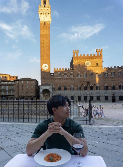 Thomas Le at a table with spaghetti in Siena