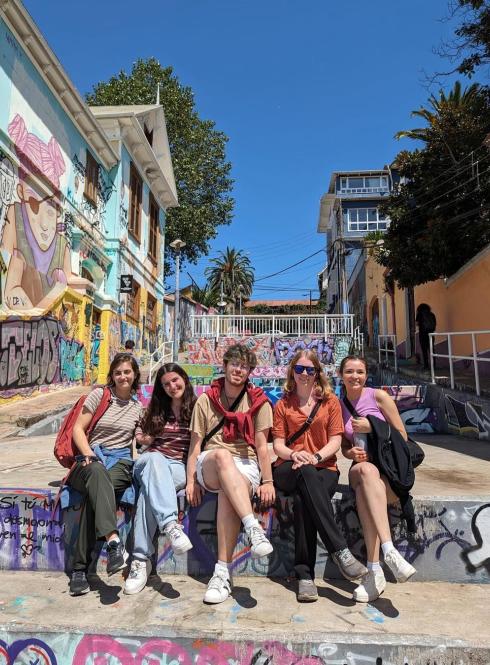 A group of students pose for a photo in the graffitied hills of Valparaíso, Chile