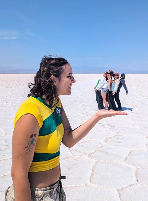 one student is in the foreground of the photo holding out their hand, while a group of students in the distance appear to be in her hand in Salta