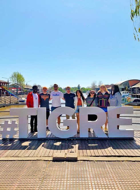 a group of students pose for a photo with a sign that says "#TIGRE"