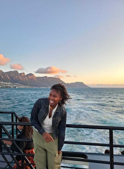 Student smiling in front of Cape Town ocean view