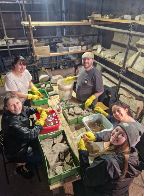 Students smiling with artifacts in the Colosseum during their internship