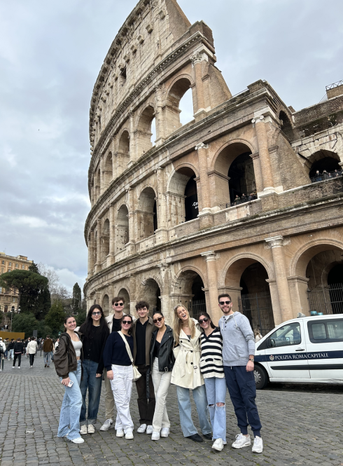 Students standing in front of the Colosseum smiling