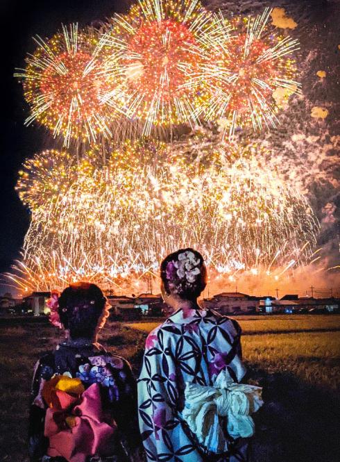 Tokyo Tonegawa Fireworks with two students standing in front of them