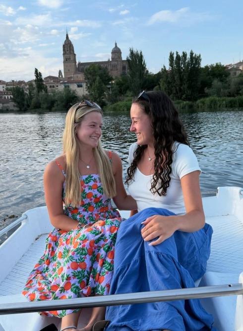 Two female students smile on the rowboats in Salamanca.