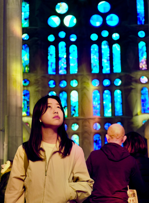 A student admiring the stunning stain glass windows inside La Sagrada Familia in Barcelona