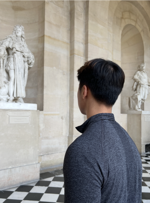 student looking at statue in Versailles