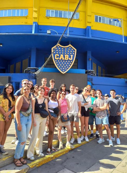 a group of students pose for a photo in front of the Buenos Aires futbol stadium