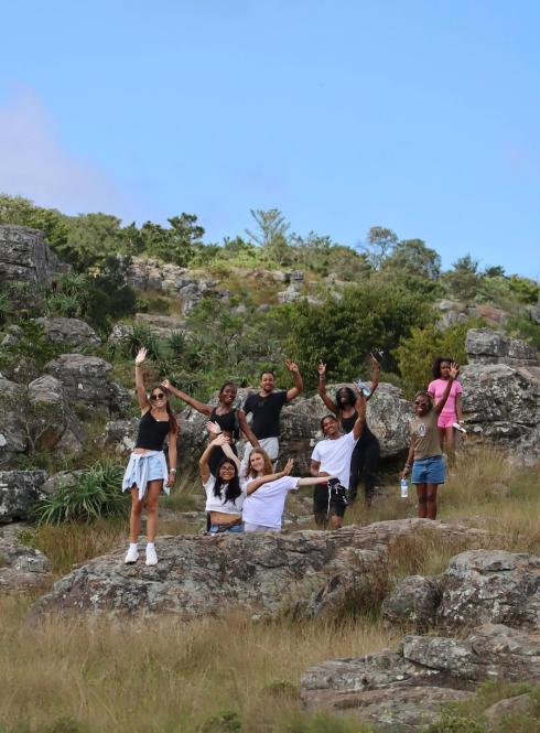Students wave from a hillside in Cape Town