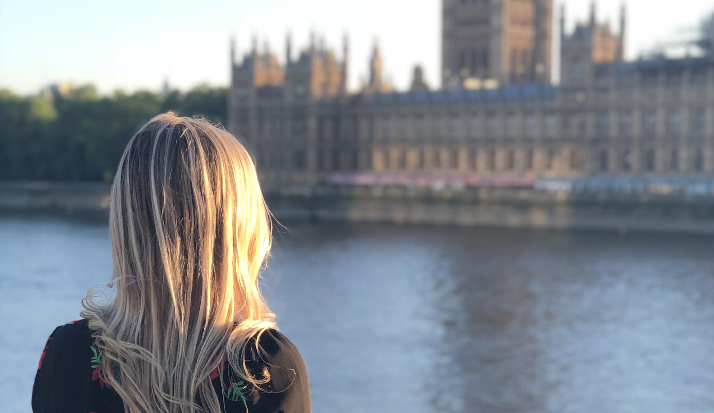 a student looks across the river Thames at British Parliament in London