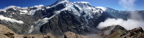 Assorted brunch dishes on a wooden table with flowers and drinks. This alt text was added with Al; accuracy may vary.