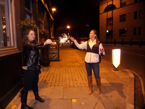 students holding sparklers on an empty sidewalk