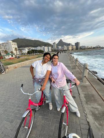 Two people standing in front of their bicycle with the mountains at the back 