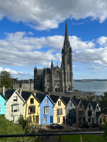 A line of colorful houses with an impressive Gothic cathedral behind them