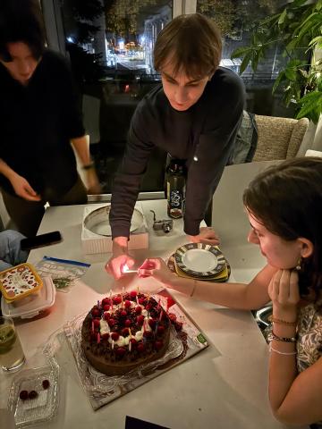 Birthday Cake being lit by two people